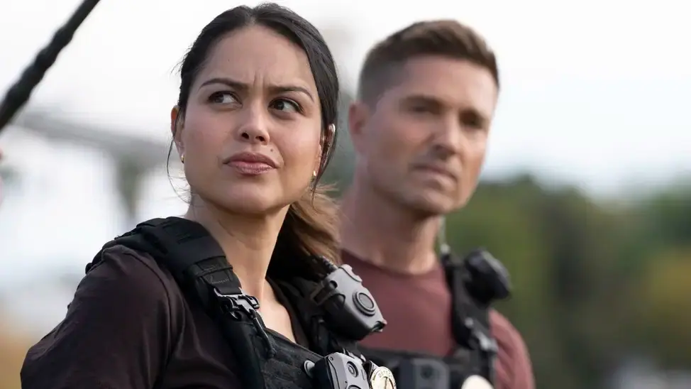 Lucy und Tim tragen ihre Polizeiuniform und blicken kritisch nach vorne.